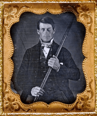 Photo: studio portrait of brain-injury survivor Phineas P. Gage (1823-1860) shown holding the tamping iron which injured him
