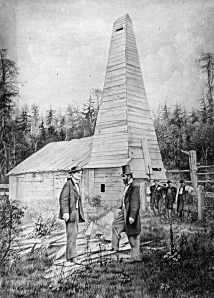 Photo: “Edwin L. Drake, to the right, and the Drake Well in the background, in Titusville, Pennsylvania, where the first commercial well was drilled in 1859 to find oil.”