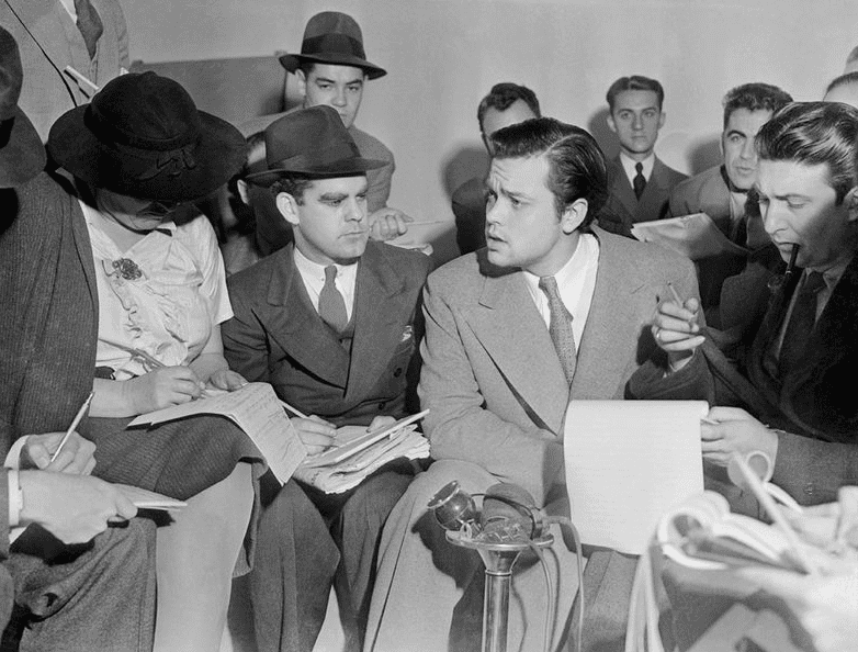 Photo: Orson Welles meeting with reporters in an effort to explain that no one connected with the War of the Worlds radio broadcast had any idea the show would cause panic, 31 October 1938