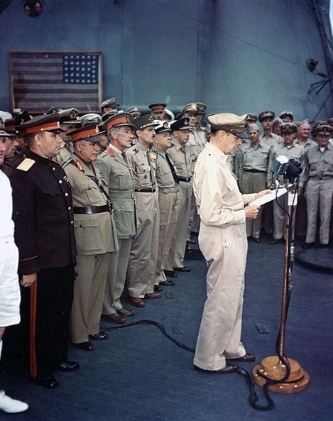 Photo: General of the Army Douglas MacArthur, Supreme Allied Commander, reading his speech to open the surrender ceremonies, on board USS Missouri, 2 September 1945