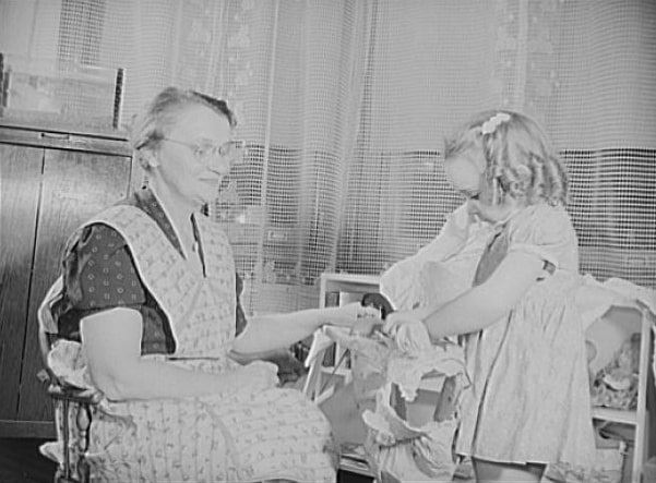 Photo: Like any other grandmother, skilled worker Eva Smuda enjoys the "children's hour" each day, and her work never leaves her too tired for those games of make-believe with five-year-old Barbara, 1942. Credit: Library of Congress, Prints and Photographs Division.
