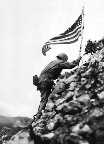 Photo: Lt. Col. Richard P. Ross Jr., commander of 3rd Battalion, 1st Marines, braves sniper fire to place the United States’ colors over the parapets of Shuri Castle during the Battle of Okinawa on 29 May 1945