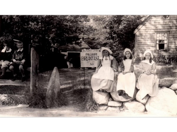 Photo: Souther Barnes (second from left) and his sister Mercie Barnes (third from left) greet guests to the Harlow Old Fort House for the Pilgrim Breakfast on 6 July 1941. The cost was only 50 cents. Courtesy of Plymouth Antiquarian Society Archives, Plymouth, Massachusetts.