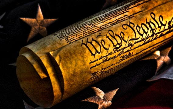 Photo: Revolutionary War flag and the U.S. Constitution. Credit: https://depositphotos.com/home.html