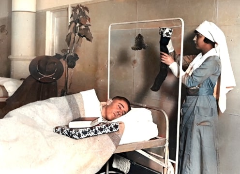 Photo: Red Cross nurse plays Santa Claus to a wounded soldier. Credit: Underwood & Underwood; American National Red Cross Archives.