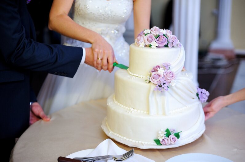 Photo: bride and groom cutting wedding cake.