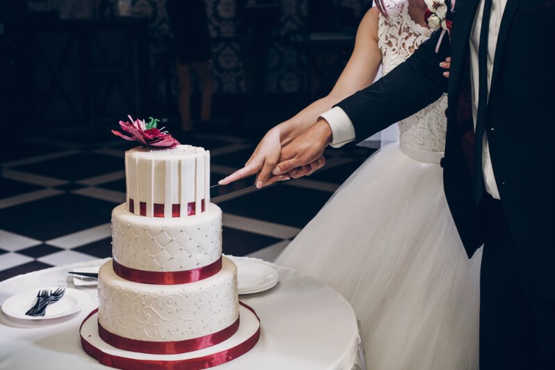 Photo: bride and groom cutting wedding cake.