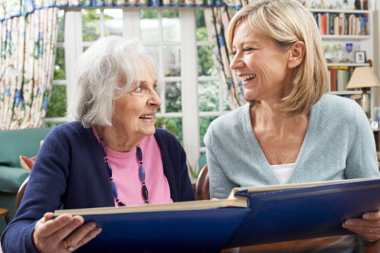 looking at a photo album with an older female relative. Credit: https://depositphotos.com/home.html