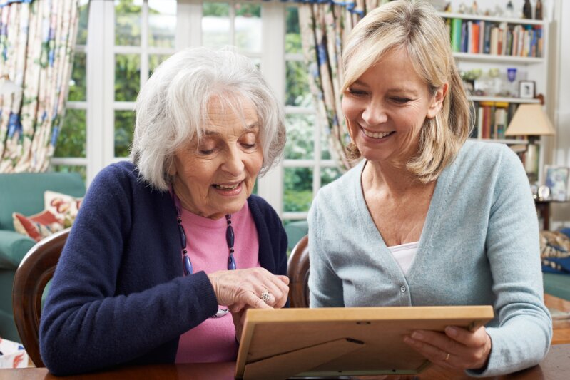 Photo: looking at a framed photo with an older female relative.